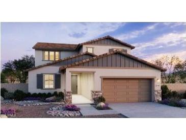 Two-story home showcasing desert landscaping, a two-car garage, neutral color palette and a covered entryway at 5439 S 251St Dr, Buckeye, AZ 85326