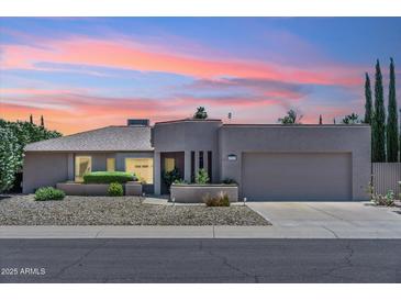 Charming single-story home featuring a two-car garage, gravel landscaping, and stylish architectural details at 6717 E Aire Libre Ln, Scottsdale, AZ 85254