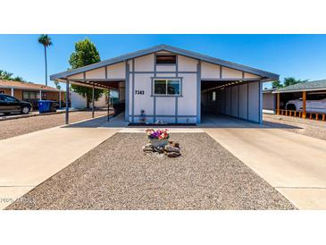 Charming home featuring a carport, lovely desert landscaping, and an inviting entrance at 7343 E Juanita Ave, Mesa, AZ 85209