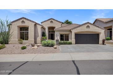 Charming single-story home featuring stucco exterior, desert landscaping, and a two-car garage at 10310 N 135Th Way, Scottsdale, AZ 85259