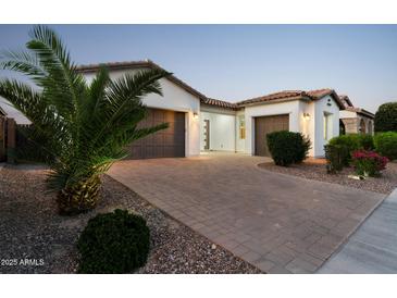 Charming home with a paver driveway, mature landscaping, and a two-car garage at 21120 E Superstition Dr, Queen Creek, AZ 85142