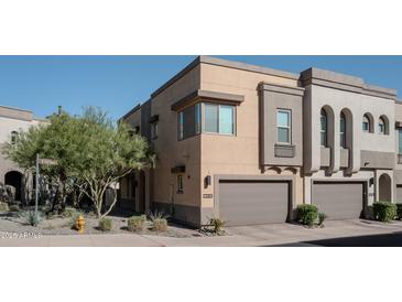 Modern townhome with a private garage and well-maintained desert landscaping enhancing the curb appeal at 23083 N 74Th Pl, Scottsdale, AZ 85255