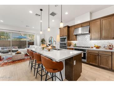 Bright kitchen featuring a large island, pendant lighting, and a seamless flow into the living area and outdoor patio at 23083 N 74Th Pl, Scottsdale, AZ 85255