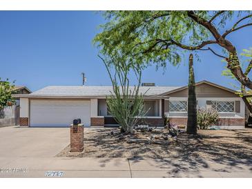 Charming single-story home with a well-manicured desert landscape, mature trees, and a two-car garage at 2432 W Echo Ln, Phoenix, AZ 85021