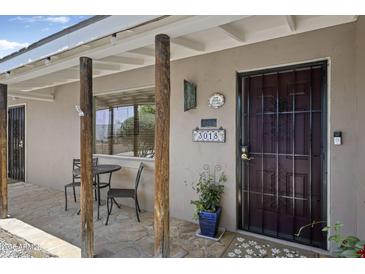 Inviting front porch with flagstone flooring and outdoor seating area by the secure entrance at 3018 E Mulberry Dr, Phoenix, AZ 85016