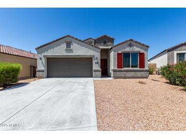 Charming single-story home features a two-car garage and desert landscaping at 30938 W Mitchell Dr, Buckeye, AZ 85396