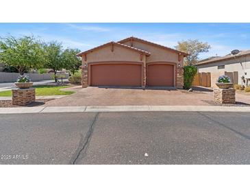 Charming home featuring a three car garage, brick driveway and beautifully landscaped yard with stone accents at 3215 E Constance Way, Phoenix, AZ 85042