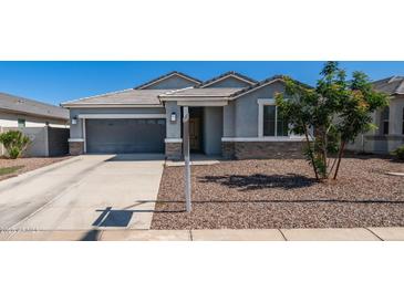 Charming single-story home featuring a well-maintained front yard, gray stucco, and a two-car garage at 44232 W Palo Cedro Rd, Maricopa, AZ 85138