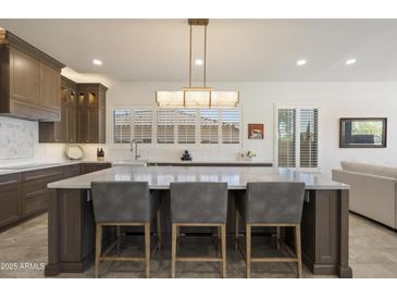 Modern kitchen with a large center island, white countertops, dark wood cabinets, and stainless steel appliances at 5332 E Thunder Hawk Rd, Cave Creek, AZ 85331