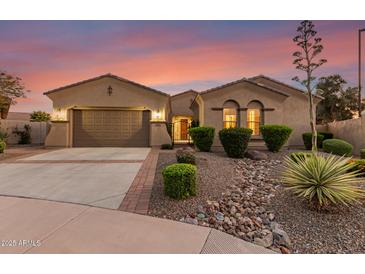 Charming single-story home featuring a well-manicured yard, desert landscaping, and a welcoming entrance with a gated courtyard at 6648 S Lyon Dr, Gilbert, AZ 85298