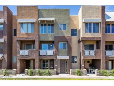 Modern townhome exterior showcasing multi-tone stucco, balconies, and well-maintained landscaping at 6745 N 93Rd Ave # 1158, Glendale, AZ 85305