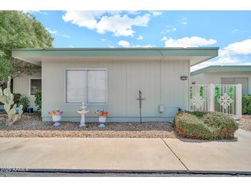 Charming single-story home with white exterior, front yard decor, and well-maintained landscaping at 13207 N 98Th Ave # L, Sun City, AZ 85351