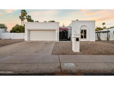Charming single-story home featuring a two-car garage, gated front entry, and low-maintenance desert landscaping at 14029 N Burning Tree Pl, Phoenix, AZ 85022