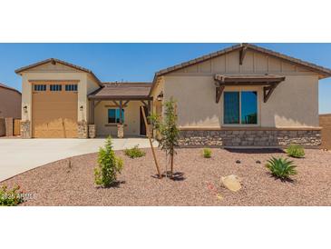 Inviting single-Gathering home features a desert landscape, neutral colors, a two car garage, and stone accents at 17304 W Royal Palm Rd, Waddell, AZ 85355