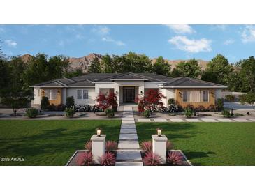 Inviting single-story home featuring manicured lawn, brick facade, and decorative pathway to the front door at 1951 E Long Rifle Rd, Phoenix, AZ 85086