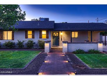 Charming single story home featuring a brick walkway, trimmed bushes, and a wreath on the front door at 2518 E Flower E St, Phoenix, AZ 85016