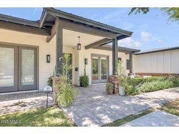 Charming home featuring a covered front entrance with a brick walkway and manicured landscaping at 3924 E Roma Ave, Phoenix, AZ 85018