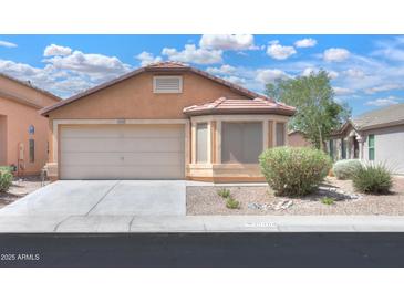 Inviting single-story home with a neutral color scheme, well-maintained landscaping, and an attached two-car garage at 40468 W Sanders Way, Maricopa, AZ 85138