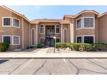 Two-story condo building with desert landscaping, a red tile roof, and private entry stairs at 5230 E Brown Rd # 114, Mesa, AZ 85205