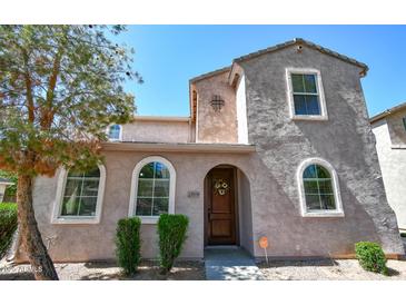 Charming two-story home featuring arched windows, a decorative front door, and well-maintained landscaping at 10136 E Isleta Ave, Mesa, AZ 85209