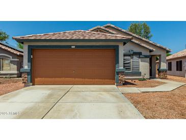 Charming single-story home showcasing a two-car garage and well-maintained desert landscaping at 14936 W Maui Ln, Surprise, AZ 85379