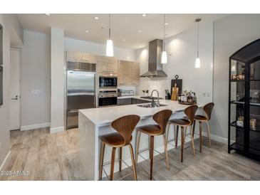 Modern kitchen with stainless steel appliances, white countertops, and a stylish island with seating at 15215 N Kierland Blvd # 101, Scottsdale, AZ 85254