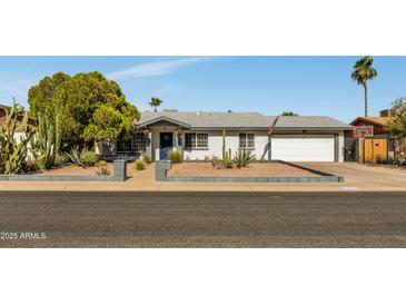 Charming single-story home with white brick, desert landscaping, and a two-car garage under a clear blue sky at 18035 N 29Th Dr, Phoenix, AZ 85053