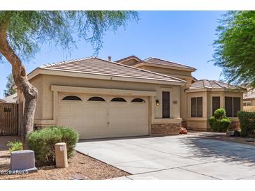 Beige home featuring a two-car garage, tile roof, and desert landscaping at 20895 E Via Del Rancho Rd, Queen Creek, AZ 85142