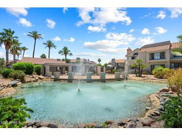 Beautiful community pool area with fountains, palm trees, and well-maintained landscaping on a sunny day at 10115 E Mountain View Rd # 2061, Scottsdale, AZ 85258