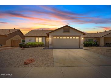 Charming single-story home featuring a two-car garage and desert landscaping against a beautiful sunset sky at 10617 W Ross Ave, Peoria, AZ 85382