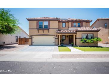 Inviting two-story home featuring a tile roof, manicured lawn, and a welcoming front porch at 13601 W Hearn Rd, Surprise, AZ 85379