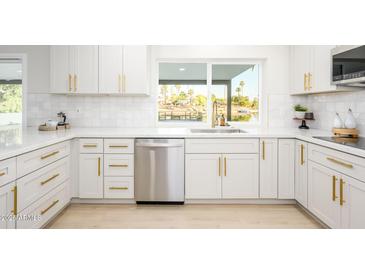 Bright kitchen featuring white cabinets, stainless steel appliances, and a window overlooking the lake at 2552 S Playa --, Mesa, AZ 85202