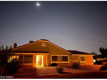 Exterior view of a single story home at dusk with desert landscaping, a welcoming porch light, and clear starry sky at 3510 E Hampton Ave # 133, Mesa, AZ 85204
