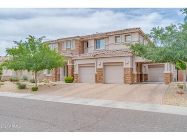 Beautiful stucco home featuring a three-car garage, manicured front yard, and stone veneer accents at 5542 W Big Oak St, Phoenix, AZ 85083