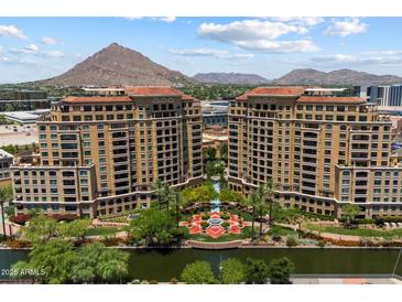 Stunning aerial view of luxury condos with mountain views, lush landscaping, and water features at 7181 E Camelback Rd # 702, Scottsdale, AZ 85251