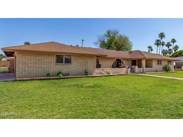 Charming single-story brick home with well-maintained lawn and arched entryway at 1004 E Gemini Dr, Tempe, AZ 85283