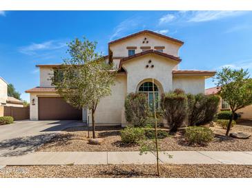 Two-story home with stucco siding, tile roof, arched window, and low-maintenance landscaping at 17153 W Gambit Trl, Surprise, AZ 85387