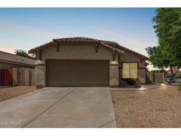 Charming single story home featuring low maintenance desert landscaping and a two car garage at 17828 W Calavar Rd, Surprise, AZ 85388