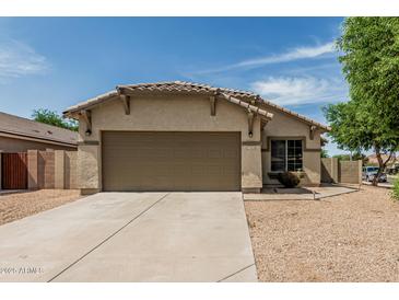 Charming single-story home with neutral stucco, tile roof, desert landscaping and a spacious two-car garage at 17828 W Calavar Rd, Surprise, AZ 85388