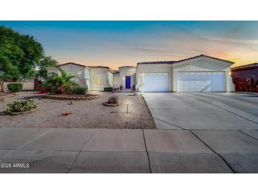 Charming single-story home boasting a three-car garage, desert landscaping, and a welcoming front entrance at 3125 W Desert Ln, Laveen, AZ 85339