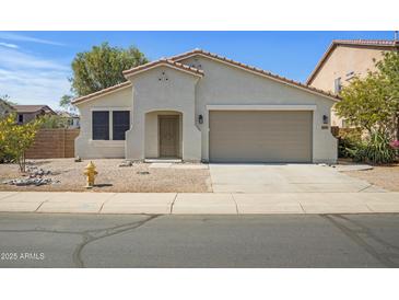 Charming single-story home with a two-car garage and low maintenance desert landscaping at 43690 W Knauss Dr, Maricopa, AZ 85138