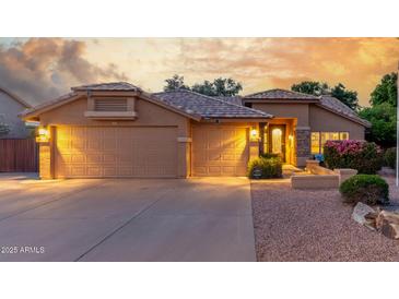 Inviting home featuring a three car garage and decorative iron work on front door at 6918 W Villa Hermosa W --, Glendale, AZ 85310