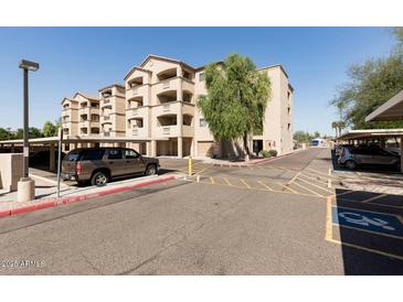 Low angle view of the exterior of a modern-style apartment building with a parking area and desert landscaping at 920 E Devonshire Ave # 2031, Phoenix, AZ 85014
