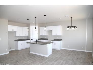 Modern kitchen with granite countertops, stainless steel faucet and modern pendant lighting at 15128 S Country Club Dr, Arizona City, AZ 85123