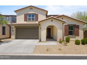 Charming two-story home features a two-car garage and a welcoming arched entryway, beautiful landscaping, and desert charm at 17721 W Cassia Way, Goodyear, AZ 85338