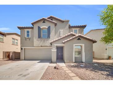 Two-story home with neutral paint, tile roof, landscaped yard, and a two car garage at 25726 W Burgess Ln, Buckeye, AZ 85326