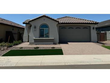 Charming single-story home with a tile roof, manicured lawn, and a brick-paved driveway leading to a two-car garage at 3375 W Verde River Rd, San Tan Valley, AZ 85144