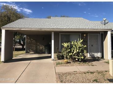Charming home featuring a quaint front yard with native desert landscaping and a convenient covered parking area at 4042 E Carson Rd, Phoenix, AZ 85042