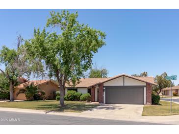Charming single-story home featuring lush landscaping and a well-maintained front yard with brick accents at 540 Leisure World --, Mesa, AZ 85206