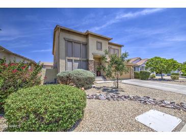 Two-story home featuring desert landscaping, stone accents, neutral paint, and a covered front porch entry at 742 W Agrarian Hills Dr, San Tan Valley, AZ 85143